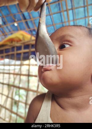 Ein Kind wurde im Flüchtlingslager Balukhali mit Suppe gefüttert. Ungefähr 919.000 Rohingya-Flüchtlinge leben in den Lagern Kutupalong und Nayapara in Cox’s Bazar – die zu einem der größten und am dichtesten besiedelten Lager der Welt geworden sind. Bangladesch. Stockfoto