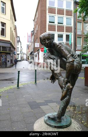 Düsseldorf, Deutschland - 2. August 2023 Bronzestatue Schuhanzieherin. Es wurde 1978 von Karl-Henning Seemann hergestellt Stockfoto