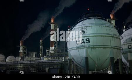 Brennbare Gas- oder LNG-Speichertanks in der Raffinerie bei Nacht, fiktiv - industrielle 3D-Illustration Stockfoto