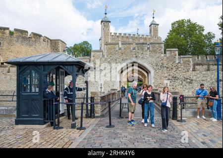 Die Leute verlassen den Tower of London. Sicherheitskabine und Wachkontrolle am Ausgang zur Tower Wharf. London, England, Großbritannien Stockfoto