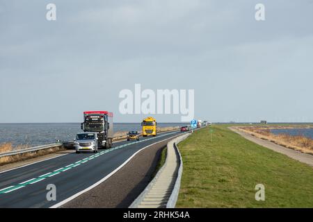 Lelystad, Niederlande. Januar 2023. Fahrzeuge sind auf dem 27 Kilometer langen Staudamm Houtribdijk zu sehen, der die Städte Lelystad und Enkhuizen in den Niederlanden verbindet. Entlang des Staudamms, zwischen dem malerischen Markermeer und dem IJsselmeer verläuft die N307-Route. Quelle: SOPA Images Limited/Alamy Live News Stockfoto