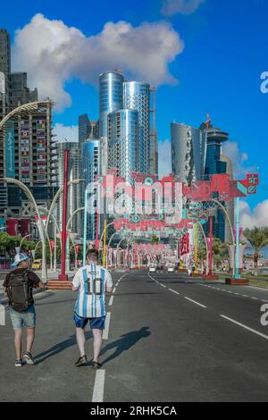 Mitten in Katars elektrischer FIFA-Weltmeisterschaft 2022 fängt ein Fußballfan einen offenen Moment ein. Zwei Freunde spazieren durch die Corniche-Fanzone, ihr aufregendes Plätzchen Stockfoto