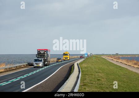 Lelystad, Flevoland, Niederlande. Januar 2023. Fahrzeuge sind auf dem 27 Kilometer langen Staudamm Houtribdijk zu sehen, der die Städte Lelystad und Enkhuizen in den Niederlanden verbindet. Entlang des Staudamms, zwischen dem malerischen Markermeer und dem IJsselmeer verläuft die N307-Route. (Credit Image: © Karol Serewis/SOPA Images via ZUMA Press Wire) NUR REDAKTIONELLE VERWENDUNG! Nicht für kommerzielle ZWECKE! Stockfoto