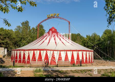 Das rot-weiß gestreifte Zelt des Wanderzirkus befindet sich im städtischen Vergnügungspark. Hochwertiges Foto Stockfoto