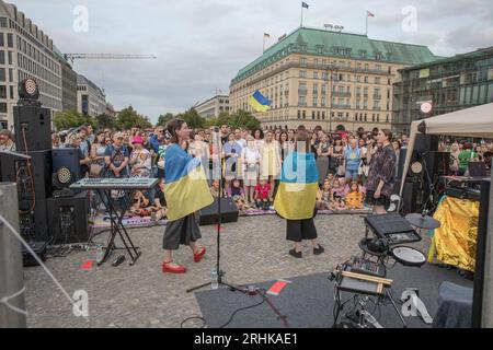 Am 17. August 2023 wurde das Brandenburger Tor, ein Symbol der Einheit und des Friedens, zum Schauplatz einer kraftvollen Demonstration von Solidarität und Widerstand. Die ukrainischen Hip-Hop-Pioniere TNMK (Tanok na Maidani Kongo) traten in einem Benefizkonzert auf die Bühne, das ebenso eine musikalische Extravaganz wie eine politische Aussage war. Der Abend war voller Emotionen, als sich Ukrainer versammelten, viele schwenkten ukrainische Flaggen, um die Sache der ukrainischen Freiheit zu unterstützen. Die Luft war voll mit Gesängen von "Russland ist ein terroristischer Staat", eine Stimmung, die von vielen Anwesenden aufgegriffen wurde. Ein riesiges Banner, das von den Teilnehmern hochgehalten wurde, trug sich Stockfoto