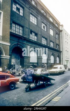 1970er Jahre Archivfoto von man Pushing barrow in Soho, London. Stockfoto