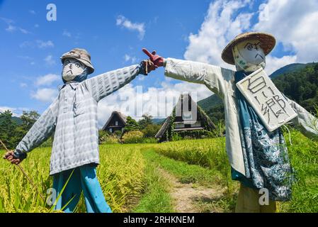 Vogelscheuchen vor den traditionellen Gassho-zukuri Strohhütten aus Holz im Dorf Shirakawa-Go, Präfektur Gifu, Japan Stockfoto