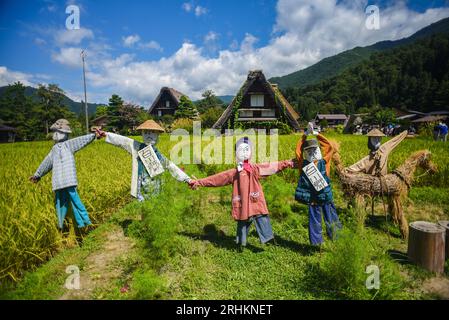 Vogelscheuchen vor den traditionellen Gassho-zukuri Strohhütten aus Holz im Dorf Shirakawa-Go, Präfektur Gifu, Japan Stockfoto