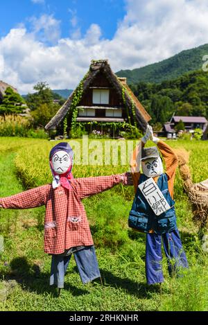 Vogelscheuchen vor den traditionellen Gassho-zukuri Strohhütten aus Holz im Dorf Shirakawa-Go, Präfektur Gifu, Japan Stockfoto