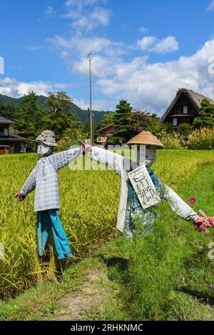 Vogelscheuchen vor den traditionellen Gassho-zukuri Strohhütten aus Holz im Dorf Shirakawa-Go, Präfektur Gifu, Japan Stockfoto