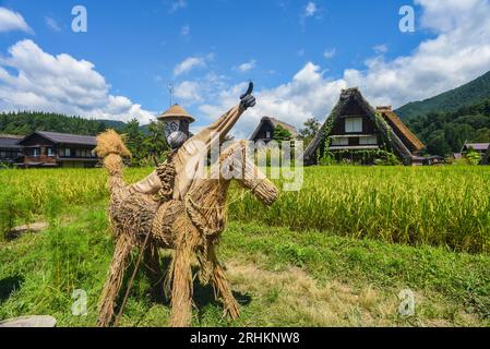 Vogelscheuchen vor den traditionellen Gassho-zukuri Strohhütten aus Holz im Dorf Shirakawa-Go, Präfektur Gifu, Japan Stockfoto