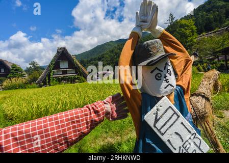 Vogelscheuchen vor den traditionellen Gassho-zukuri Strohhütten aus Holz im Dorf Shirakawa-Go, Präfektur Gifu, Japan Stockfoto