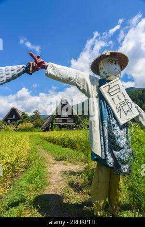 Vogelscheuchen vor den traditionellen Gassho-zukuri Strohhütten aus Holz im Dorf Shirakawa-Go, Präfektur Gifu, Japan Stockfoto