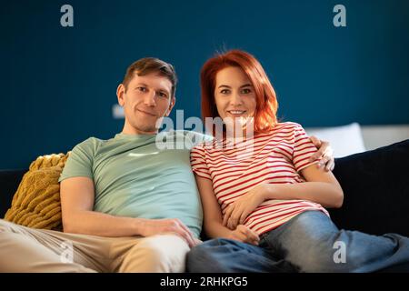 Gut ausgeruhter Mann und Frau im mittleren Alter, reifes, liebendes Ehepaar, entspanntes Sitzen auf der Couch zu Hause. Stockfoto