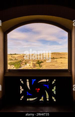 Segovia, Spanien, Landschaft am Stadtrand mit Kirche La Vera Cruz aus dem Fenster mit floralen Glasmalereien in Alcazar von Segovia. Stockfoto