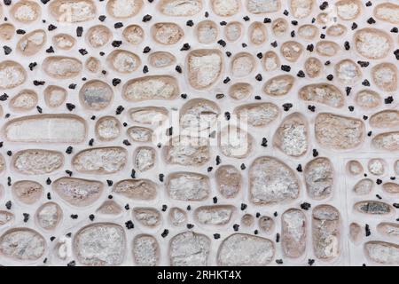 Steinfassade des Alcazar von Segovia, Spanien, runde Steine in der Wandfassade mit kleinen schwarzen Steinen dazwischen. Stockfoto