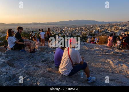 Athen, GR - 29. Juli 2023: Menschen, die den Sonnenuntergang auf dem Areopagus-Hügel betrachten Stockfoto