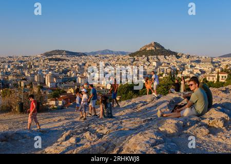 Athen, GR - 29. Juli 2023: Menschen, die den Sonnenuntergang auf dem Areopagus-Hügel betrachten Stockfoto
