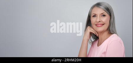 Porträt einer schönen Reifen Frau auf hellgrauem Hintergrund. Bannerdesign mit Platz für Text Stockfoto
