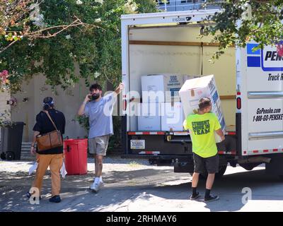 NEW ORLEANS, LA, USA - 17. AUGUST 2023: Arbeiter von der USS (University and Student Services) für Tulane University, die Kisten von LKW zu Wohnung transportieren Stockfoto