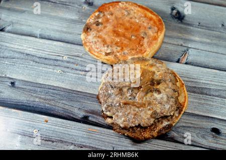 Doppelt saftiges, dickes Rinderpatty mit Käse, der mit Sauce bedeckt ist, Pilzen in einem großen Sesambrötchen, ein Hamburger-Sandwich mit Rindfleisch und spezieller Sauce Stockfoto