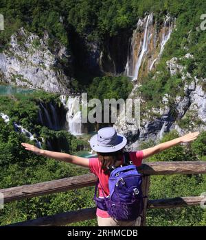 Teenager-Touristen bewundern Wasserfälle im Nationalpark Plitvicer Seen, Kroatien, Europa. Majestätische Aussicht mit türkisfarbenem Wasser Stockfoto