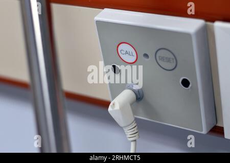 Ein Gerät für den Anruf von Patienten in einem stationären Raum in einem Krankenhaus mit einem Anruf- und Reset-Schalter, die für Notfälle verwendet werden, um die Pflegekräfte in Not an der Wand anzurufen Stockfoto