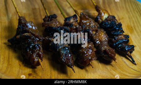 Sate Ayam oder Chicken Satay auf einem Holzteller serviert Stockfoto