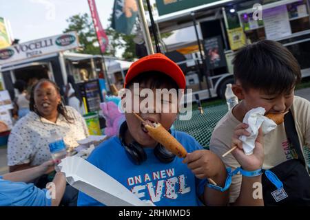 Gaithersburg, Maryland, USA. Aug. 2023. Fairgoers genießt Corndogs auf der Montgomery County Fair 2023 in Gaithersburg, Maryland. Freitagabend findet auf der Messe das jährliche Event Demolition Derby: Night of Destruction statt. (Bild: © Eric Kayne/ZUMA Press Wire) NUR REDAKTIONELLE VERWENDUNG! Nicht für kommerzielle ZWECKE! Stockfoto