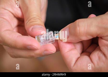 Man-Hand-Befestigung des Netzkabels am RJ45-Steckverbinder. Stockfoto