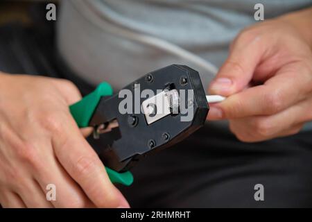 Man-Hand-Befestigung des Netzkabels am RJ45-Steckverbinder mit Datenkabel-Crimper. Stockfoto