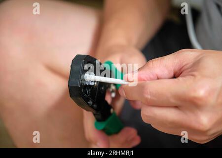 Man-Hand-Befestigung des Netzkabels am RJ45-Steckverbinder mit Datenkabel-Crimper. Stockfoto