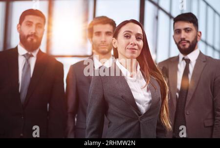 Porträt eines lächelnden Teams in der Reihe, das anders posiert und die Kamera anschaut. Stockfoto