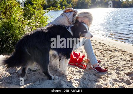 Besitzer mit einem sibirischen laika Hund am Strand. Freundschaft zwischen Hund und Frau Stockfoto