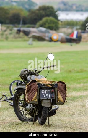 Vintage-Militärmotorrad und -Fahrrad in einem Szenario des Zweiten Weltkriegs mit einem Hawker Hurricane auf der Landebahn in Shoreham, Großbritannien. 1941 KOF Stockfoto