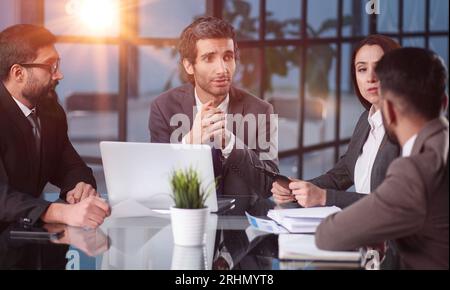 Verschiedene Mitarbeiter versammelten sich im Büro und hatten Spaß beim Brainstorming, während sie über neue Ideen für ihr neues Projekt diskutierten. Stockfoto