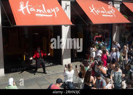 Ein Entertainer führt am 16. August 2023 in London vor dem Spielwarenladen Hameys in der Regent Street eine Song- und Tanzroutine für Käufer auf. Stockfoto