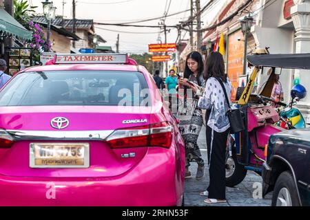 Bangkok, Thailand - 17. Januar 2023: Touristen, die ein Taxi bestellen, werden auf der Straße in Bangkok gesehen. Stockfoto