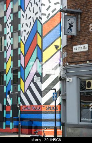 Vollständige Ansicht des Wandgemäldes von Camille Walala in der Singer Street, Shoreditch, London, jetzt entfernt – kühne geometrische Straßenkunst mit urbanem Ambiente. Stockfoto