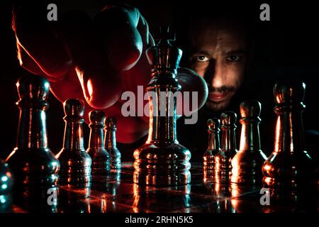 Spielen der Schachbesprechung des Königs, umgeben von Spielfiguren Stockfoto