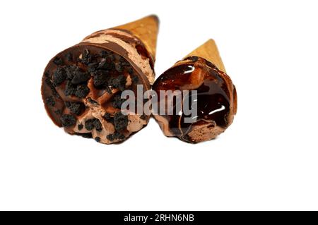 Eis aus cremiger Kakaoschokolade mit Schokoladensauce und Brownie-Stücken in knusprigen Waffelkonen, schmelzendes kaltes Eis in A Stockfoto