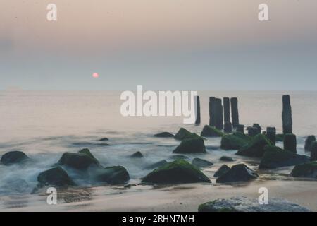 Sonnenaufgang über felsigem Strand in Delaware. Stockfoto
