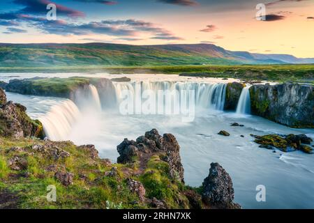 Majestätische Landschaft des Godafoss-Wasserfalls oder Wasserfall der Götter fließender und farbenprächtiger Sonnenuntergangshimmel auf dem Skjalfandafljot-Fluss im Sommer auf Nordisland Stockfoto