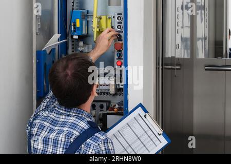 Techniker Reparieren Bedienfeld Des Defekten Elevators Stockfoto