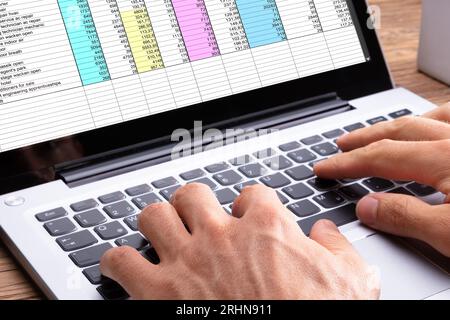 In der Nähe von Hand eintippen einer Person auf dem Laptop über Holz- Schreibtisch Stockfoto