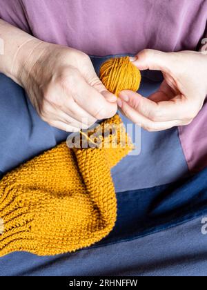 Vorderansicht der Frauenhände – Nahaufnahme des gestrickten Pullovers Stockfoto