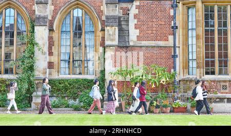 Eine Gruppe von Touristen spaziert vorbei am Speisesaal des Pembroke College, gegründet im 14. Jahrhundert, University of Cmbridge, England Stockfoto