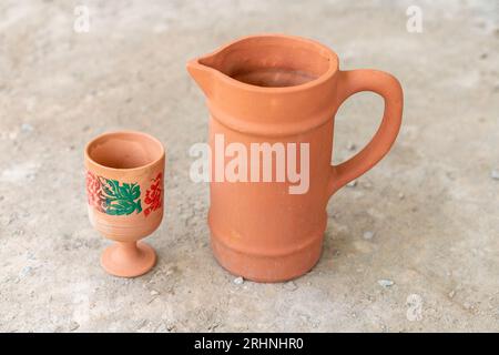 Handgemachte Tonwasserkanne mit Glas Stockfoto