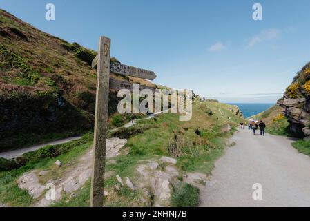 Ein hölzerner Wegweiser führt die Menschen zum Strand und zum Schloss in Tintagel in Cornwall Stockfoto