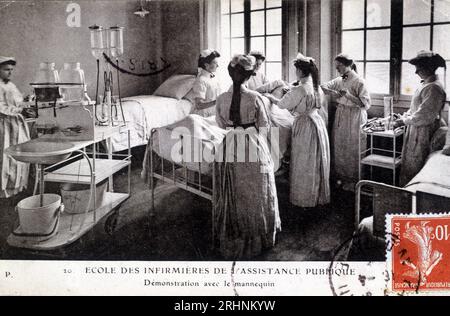 Carte postale de l'ecole des infirmieres de l'Assistance publique : Demonstration avec le mannequin, Vers 1908. Bibliothèque Marguerite Durand. Stockfoto